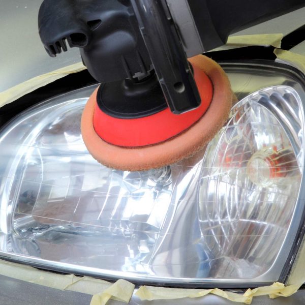 Put ka Sjaju: Materijali za Poliranje Farova Sliku prikazuje proces poliranja automobilskih farova. Na slici su jasno vidljivi materijali poput vodene smirgle, polir paste, spreja sa vodom, meke krpe i zaštitne trake, ključni za postizanje besprekornog sjaja farova.
